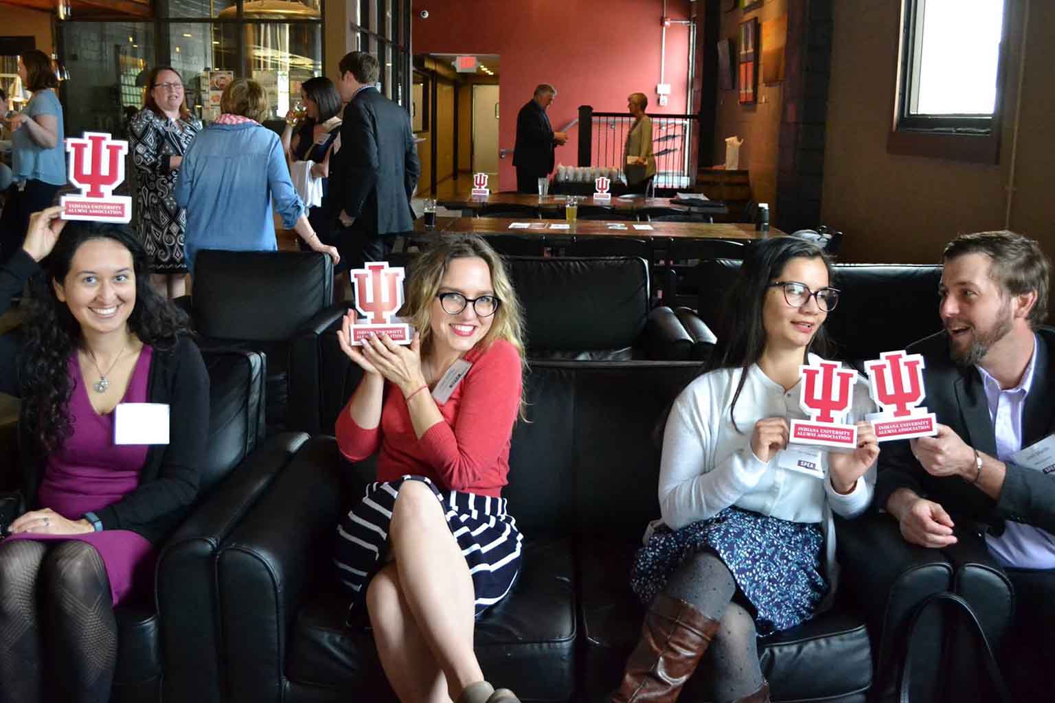 People pose with IU table tents in a bar or lounge.