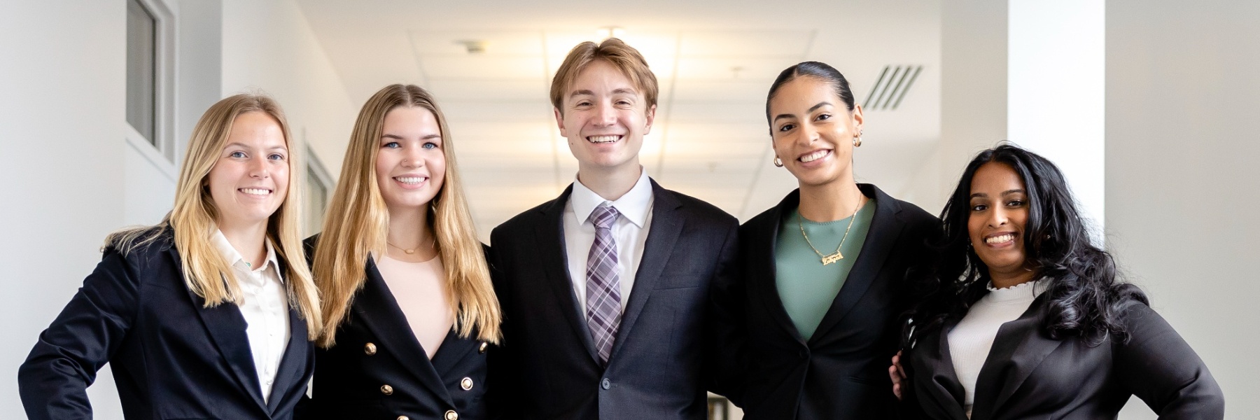 five smiling students in business attire